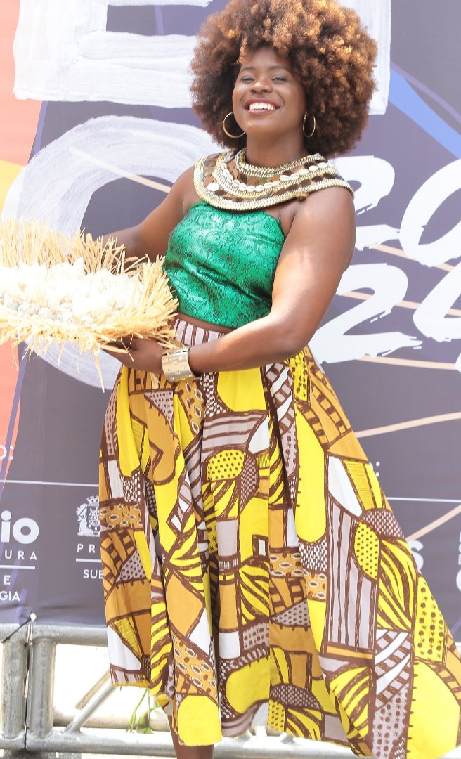 Mulher negra em traje afro-brasileiro no palco do Festival